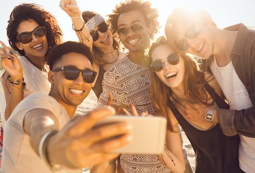 A group of friends posing for a picture on the beach