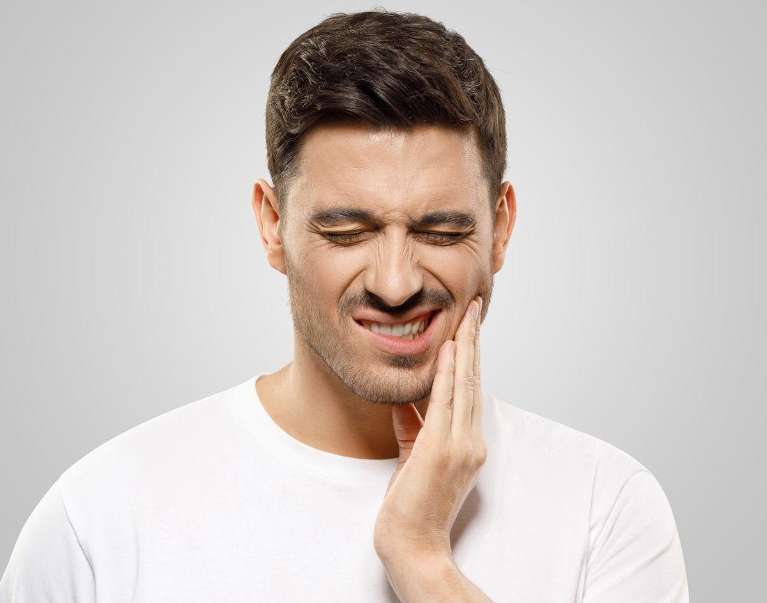 A man in a white shirt with a toothache in Langhorne