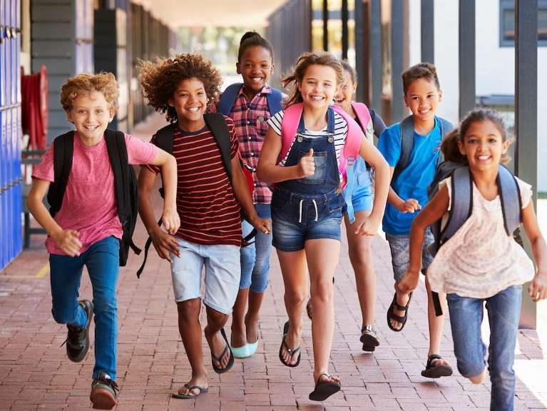 A group of school children running outside