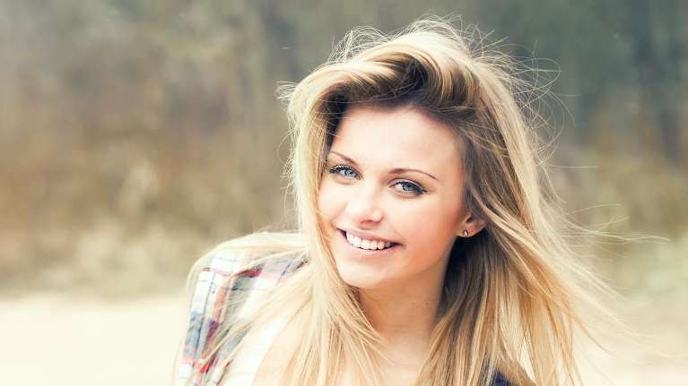 A smiling woman at the park | cosmetic dentistry Langhorne PA