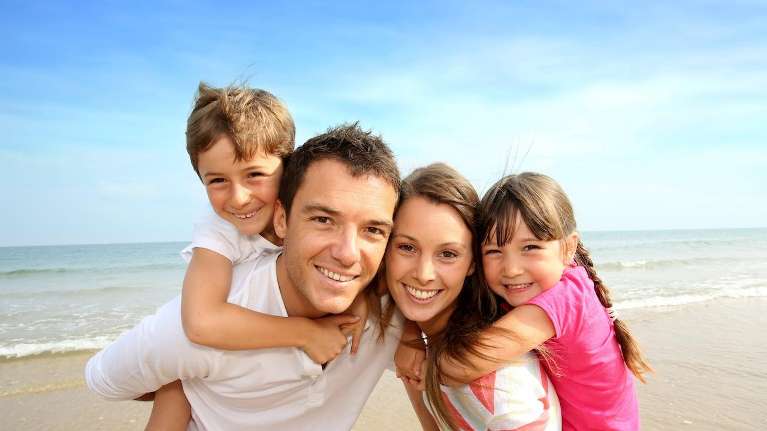 Parents playing with their children on the beach | dentist Langhorne PA