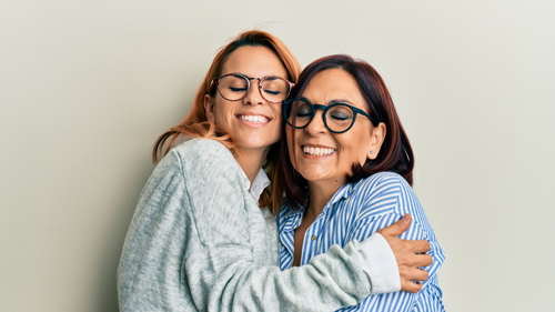 Mother daughter smiling and hugging